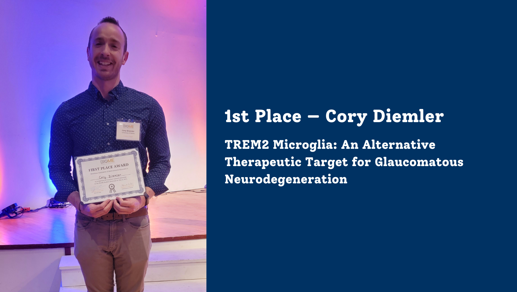 Photo of Cory Diemler, GSBSE Ph.D. student standing in front of the stage, holding his 1st place award certificate.