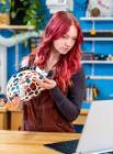 Jessica Howard looking at a computer and holding a research device.